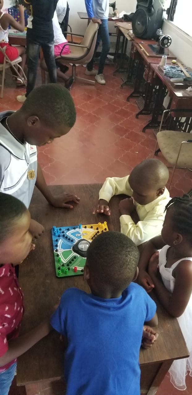 Children playing a board game with mentors at Zacchaeus Ministry